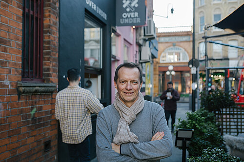 Christophe Noblet stands in an alleyway 